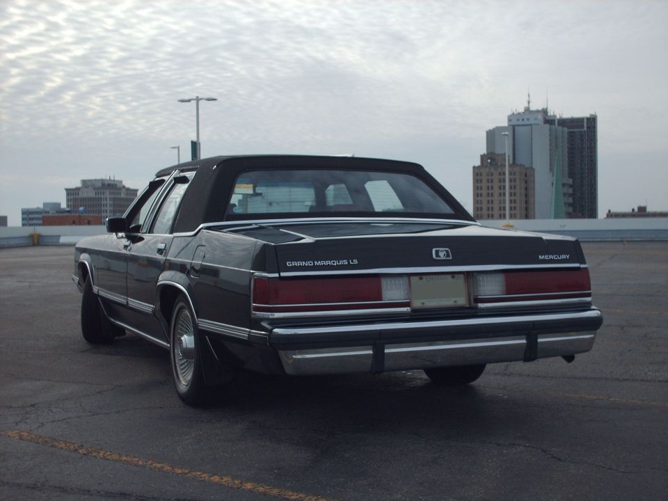 1991 Mercury Grand Marquis LS sedan, rear 3/4 view, parked on rooftop with city buildings in background