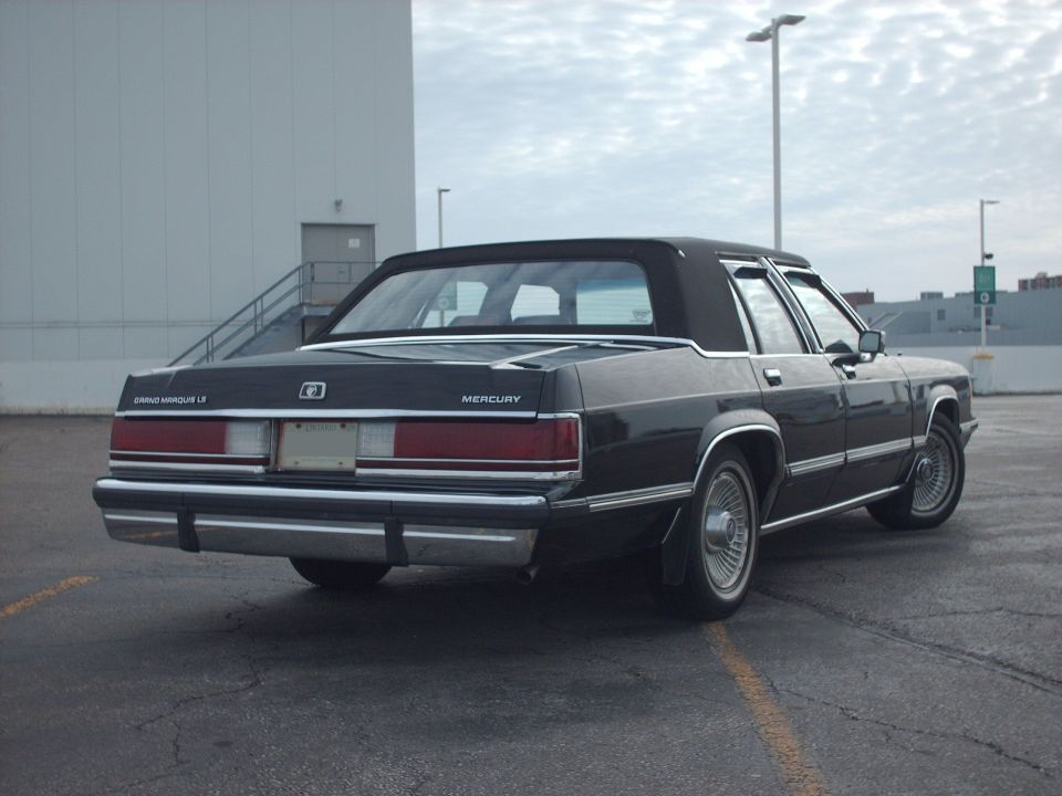 Black Mercury Grand Marquis LS sedan, rear three-quarter view in a parking lot