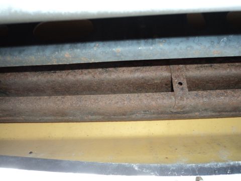 2004 Mercury Grand Marquis - Close-up view of the vehicle's undercarriage, showing rusted components and a yellow painted section.