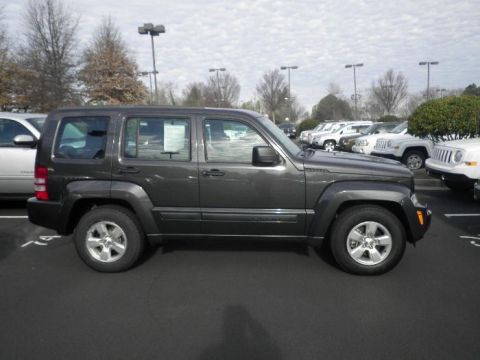 2011 Jeep Liberty - Side profile of a dark gray 2011 Jeep Liberty parked in a lot with other vehicles.