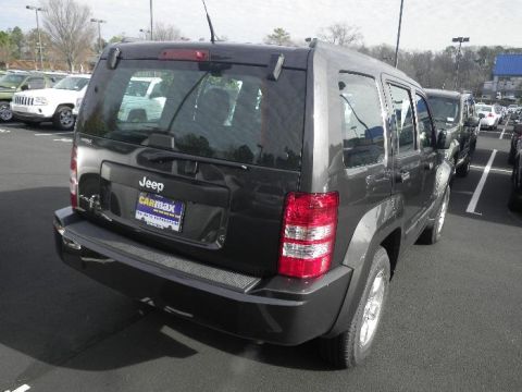 2011 Jeep Liberty - Rear view of a dark gray Jeep Liberty SUV, parked in a lot with other vehicles.