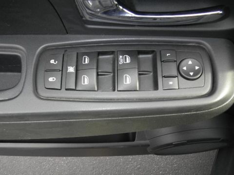 2011 Jeep Liberty - Close-up of a car's interior door panel showing power window and lock controls.
