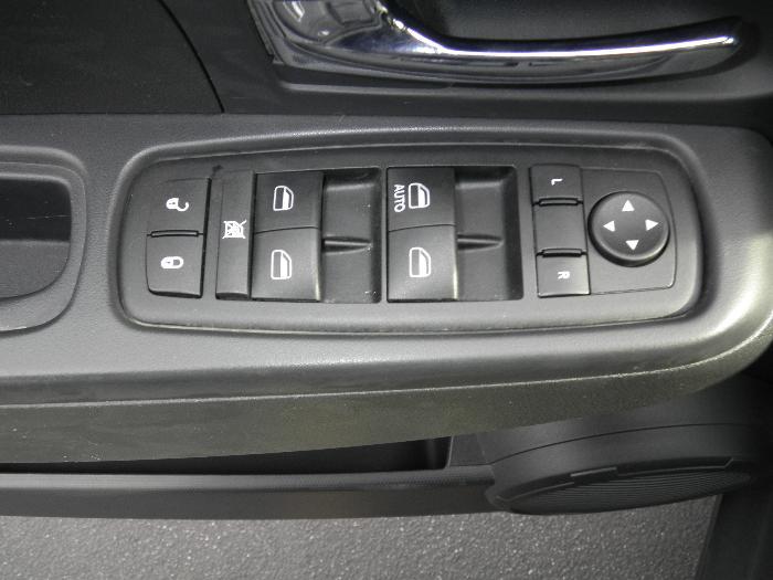 Car door panel with power window controls, lock buttons, and mirror adjustment