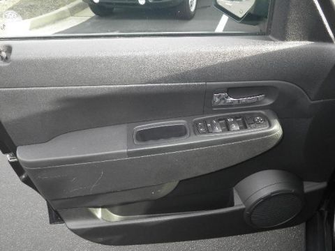 2011 Jeep Liberty - Close-up of the interior door panel, showing window controls and a speaker grille.