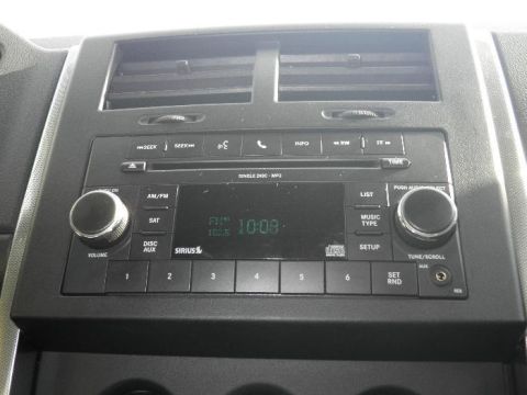 2011 Jeep Liberty - Close-up of a car's center console, the radio and climate controls.