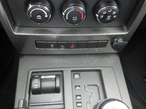 2011 Jeep Liberty - Close-up of a vehicle's interior dashboard, showing climate controls and drive mode selectors.
