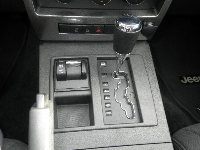 Interior center console of a 2011 Jeep Liberty showing gear shifter and 4WD selector