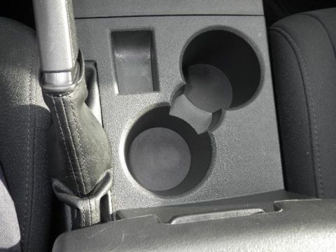 2011 Jeep Liberty - Close-up of the center console interior, cup holders and the gear shift boot.