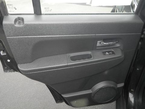 2011 Jeep Liberty - Close-up of a car's interior door panel, including the handle and window controls.