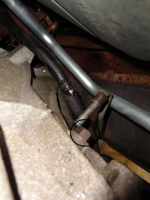 1994 Ford Bronco - A close-up view of a transmission component, showing a metal fitting and associated hoses.