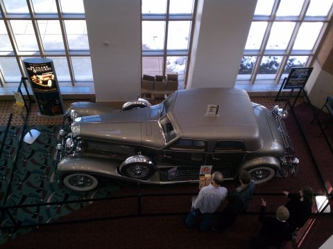 1998 Toyota Camry - This vintage car is on display indoors with people observing it.