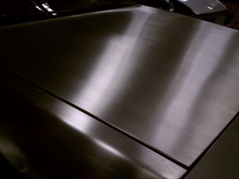 1998 Toyota Camry - Close-up of a car's brushed metal hood, with another vehicle partially visible behind it.