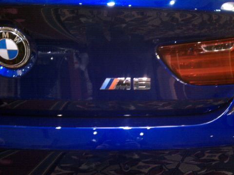 1998 Toyota Camry - Close-up of the rear emblem on a blue BMW, showing the M8 designation.