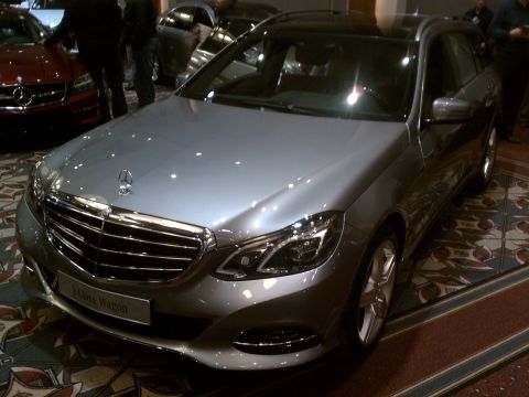 1998 Toyota Camry - Silver Mercedes-Benz E-Class Wagon displayed indoors with other vehicles present.