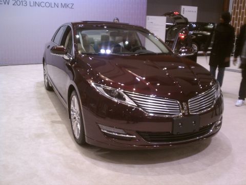 1998 Toyota Camry - A maroon Lincoln MKZ is displayed at a car show, with other vehicles and people in the background.