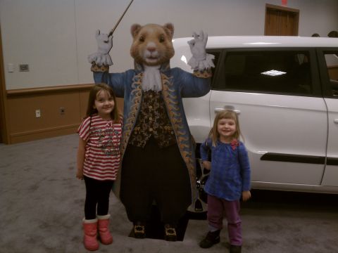 1998 Toyota Camry - A mascot stands between two children, with a white SUV visible behind them.