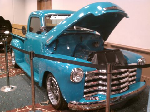 1998 Toyota Camry - A bright blue pickup truck is displayed with its hood open, revealing the engine compartment. Text is visible on the windshield.