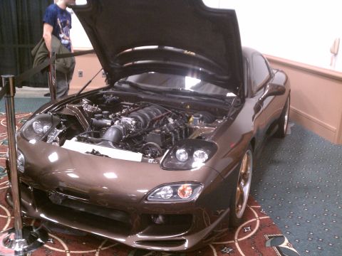 1998 Toyota Camry - A custom brown Mazda RX-7 is displayed with its hood open, revealing the engine bay.