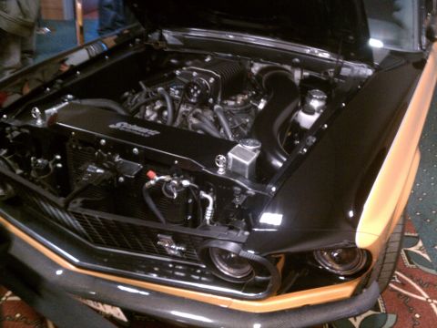 1998 Toyota Camry - Engine bay of a black and orange car, a prominent supercharger and custom radiator cover.