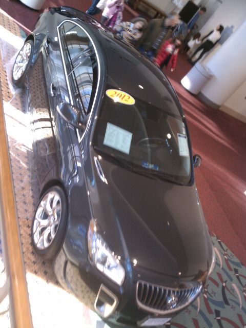 1998 Toyota Camry - A dark sedan is displayed indoors with a '2012' sticker on its windshield.