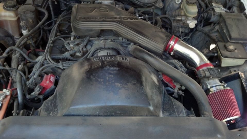1993 Mercury Grand Marquis V8 engine with aftermarket cold air intake and red air filter.