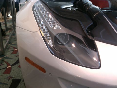 1998 Toyota Camry - Close-up of a white sports car's front corner, revealing its intricate LED headlights and an open hood.