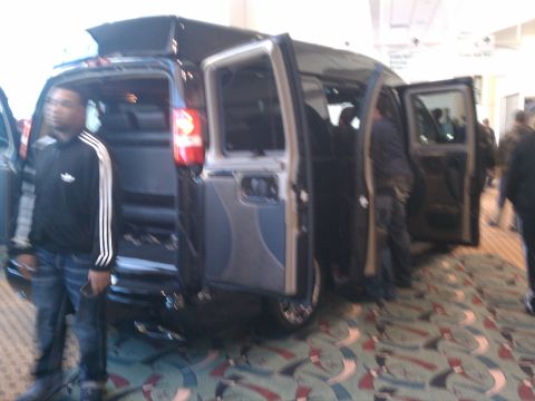 1998 Toyota Camry - A black van with its doors open, revealing people inside and a person standing by the driver's side.
