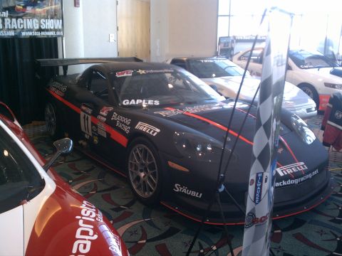 1998 Toyota Camry - A black Chevrolet Corvette C6 race car is displayed indoors with other vehicles.
