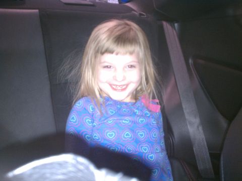1998 Toyota Camry - A young girl smiles from the back seat of a car, with a seatbelt visible.