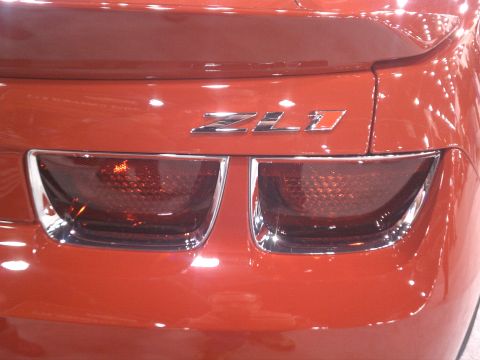 1998 Toyota Camry - The rear of a red Chevrolet Camaro ZL1 is shown, its distinctive taillights and badging.