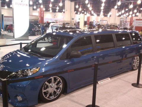 1998 Toyota Camry - A blue minivan with custom wheels and a lowered suspension is displayed at a car show.