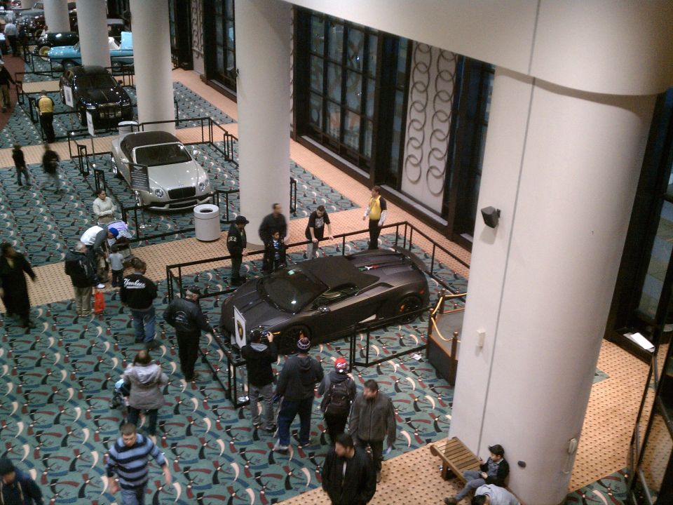 Dark sports car on display at an auto show, viewed from above