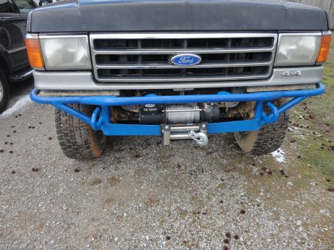 1990 Ford Bronco - Front view of a 1990 Ford Bronco a custom blue front bumper with an integrated winch.