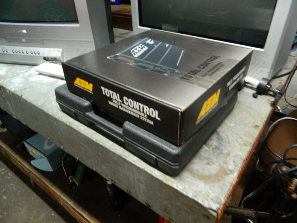 AEM Total Control engine management system box on a black case