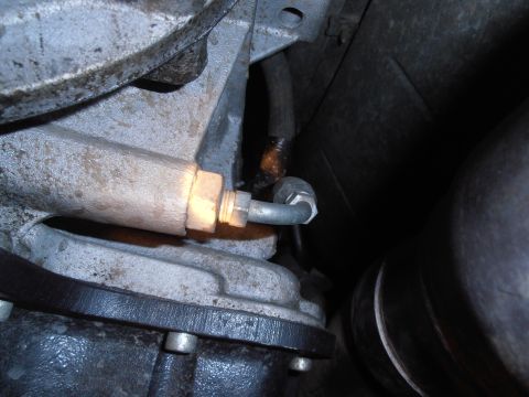 1990 Ford Bronco - Detail of a vehicle's transmission system, showing a connected hose and metal housing.