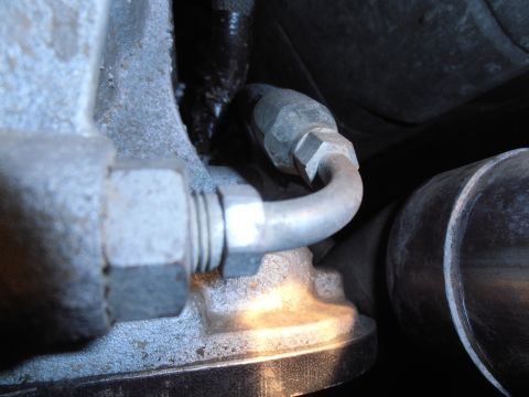 1990 Ford Bronco - Detail of metal tubing and engine parts, likely from a vehicle's mechanical system.
