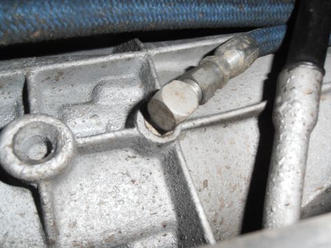 1990 Ford Bronco - Transmission housing with attached hoses, likely from a vehicle.