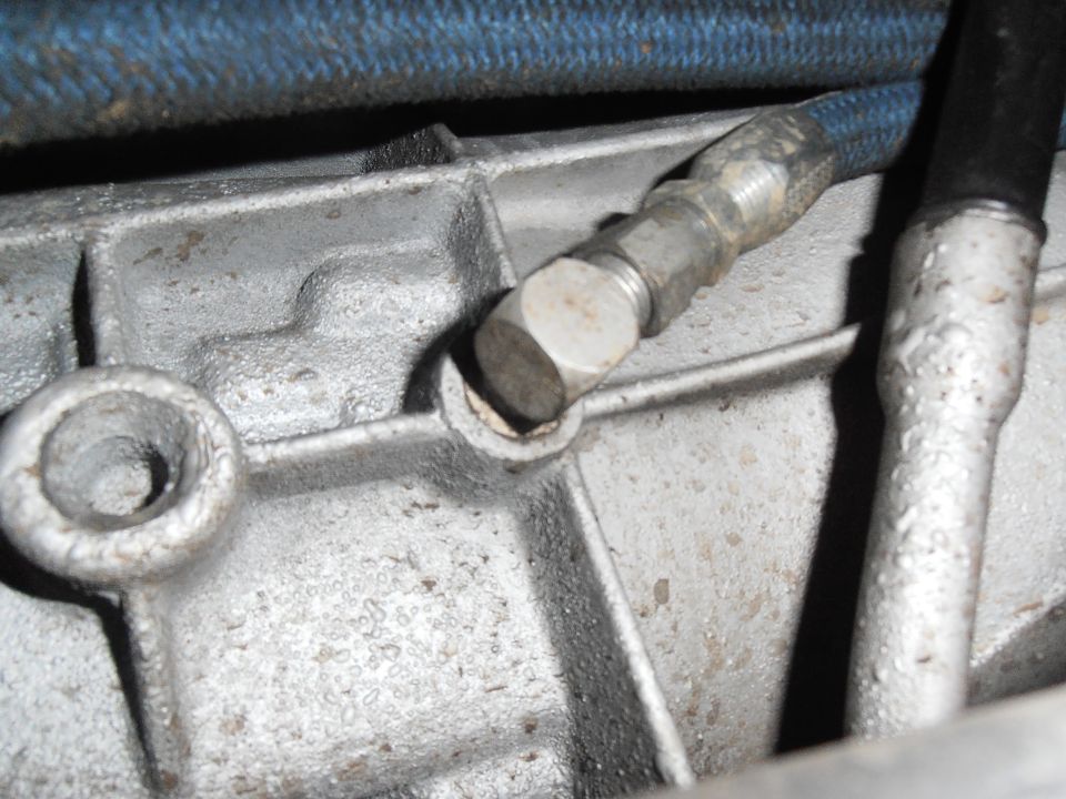 Close-up of a metal transmission housing with two hoses attached