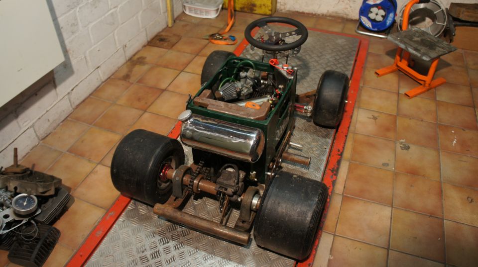 Custom go-kart with exposed engine, large rear wheels, and steering wheel