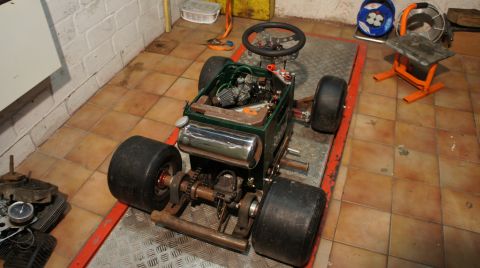 1973 Ford Ranchero - A custom-built go-kart with a visible engine and steering wheel sits on a platform in a garage setting.