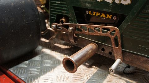 1973 Ford Ranchero - A close-up view of a Lifan engine component, a rusty hand crank and a large black tire in the background.