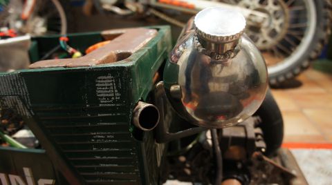 1973 Ford Ranchero - Close-up of a shiny fuel tank and part of a green frame, with a motorcycle wheel visible behind.