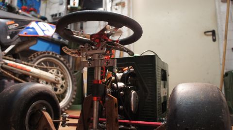 1973 Ford Ranchero - A custom-built go-kart interior is shown, a racing steering wheel and exposed engine components, with a motorcycle visible in the backgroun…