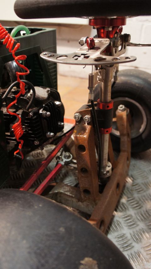 1973 Ford Ranchero - Close-up view of a go-kart's steering and front suspension system, showing custom parts.