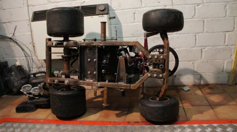 1973 Ford Ranchero - Unfinished go-kart chassis with engine and wheels, ready for assembly in a workshop.