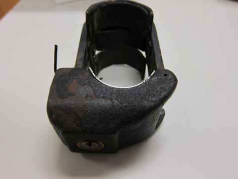 2001 Ford Crown Victoria - A close-up view of a black metal siren component, showing its weathered texture and a visible keyhole.
