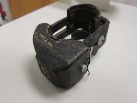 2001 Ford Crown Victoria - This is a close-up of a worn black metal lock mechanism with a keyhole.
