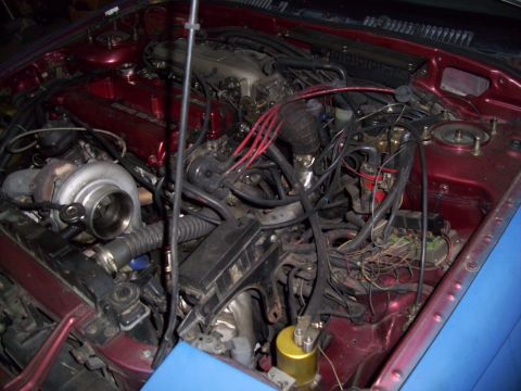 1995 Ford Probe - A close-up view of a modified engine bay, a turbocharger and extensive wiring.