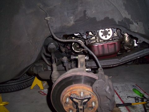 1995 Ford Probe - Underneath view of a car's front suspension and engine components, showing brake assembly.