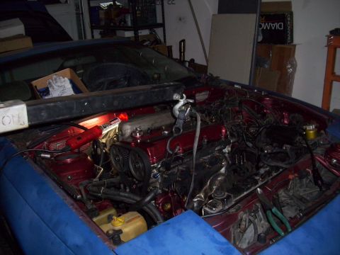 1995 Ford Probe - The engine bay of a car is shown with the hood open, revealing the engine and surrounding components.